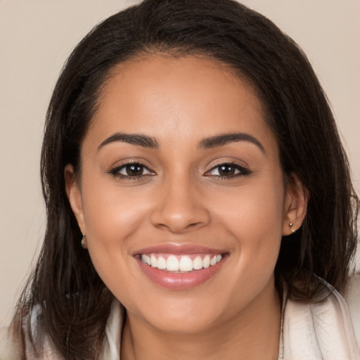 Joyful latino young-adult female with long  brown hair and brown eyes