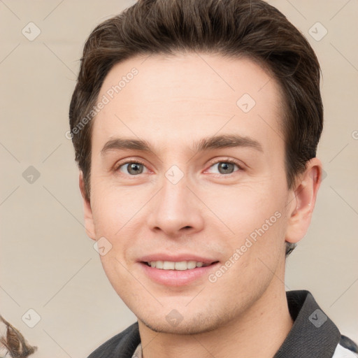 Joyful white young-adult male with short  brown hair and grey eyes