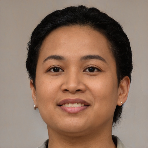 Joyful latino young-adult female with short  black hair and brown eyes