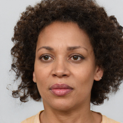 Joyful black adult female with medium  brown hair and brown eyes
