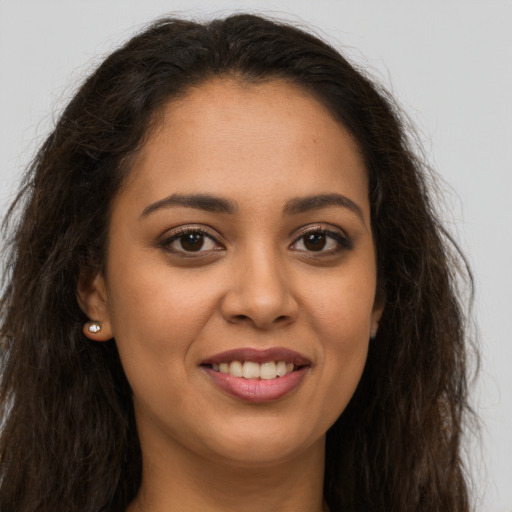 Joyful latino young-adult female with long  brown hair and brown eyes