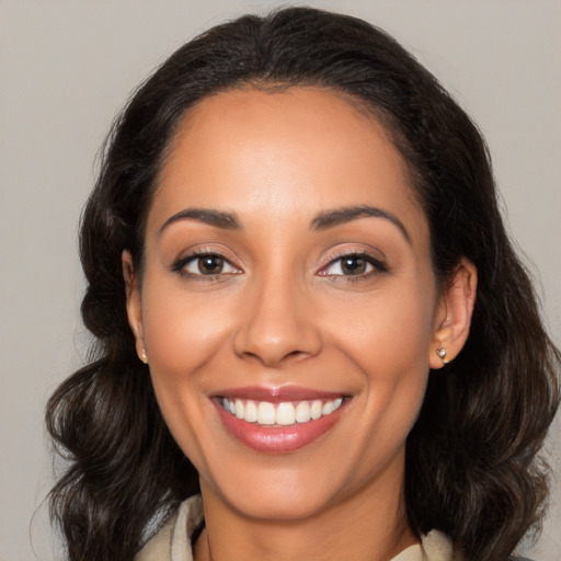 Joyful latino young-adult female with medium  brown hair and brown eyes