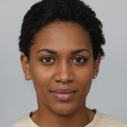 Joyful black young-adult female with short  black hair and brown eyes
