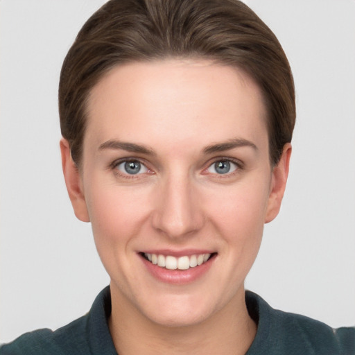 Joyful white young-adult female with short  brown hair and grey eyes