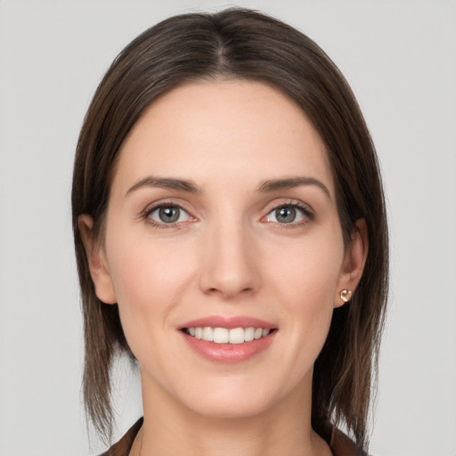 Joyful white young-adult female with medium  brown hair and grey eyes