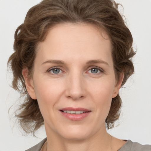 Joyful white adult female with medium  brown hair and grey eyes