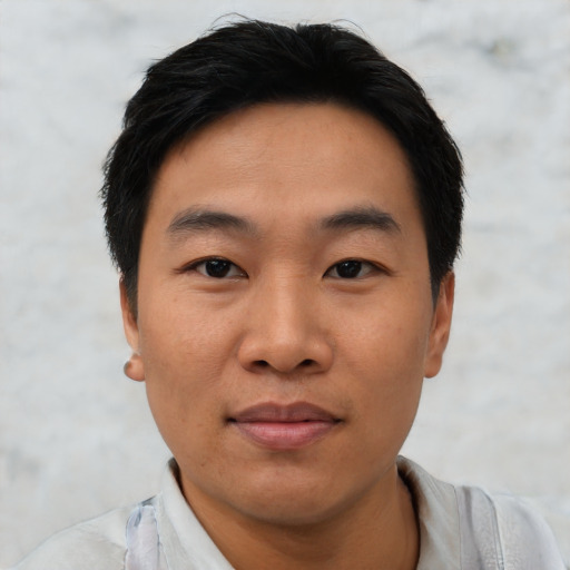 Joyful asian young-adult male with short  black hair and brown eyes