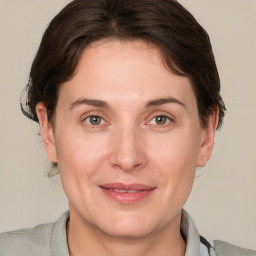 Joyful white adult female with medium  brown hair and grey eyes