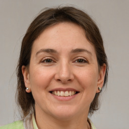 Joyful white adult female with medium  brown hair and grey eyes