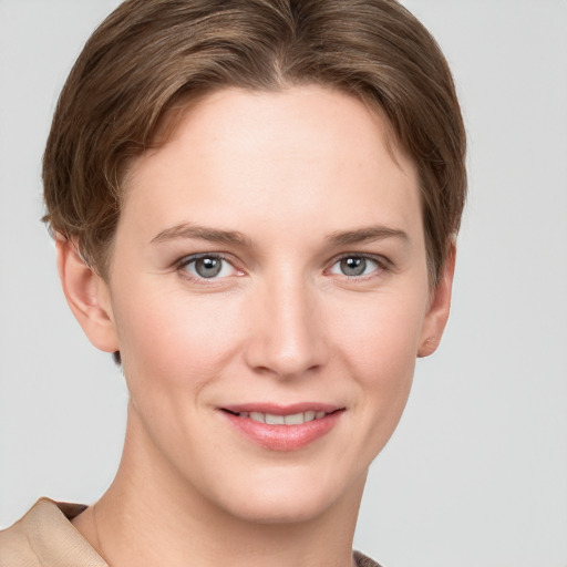 Joyful white young-adult female with short  brown hair and grey eyes