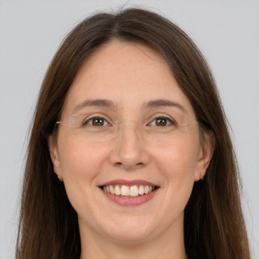 Joyful white adult female with long  brown hair and grey eyes