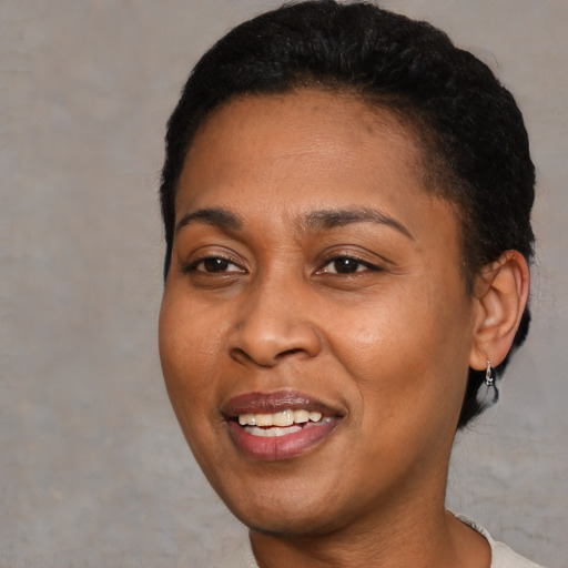 Joyful black young-adult female with short  black hair and brown eyes