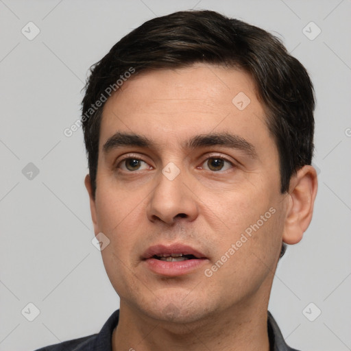 Joyful white young-adult male with short  black hair and brown eyes