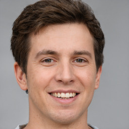 Joyful white adult male with short  brown hair and grey eyes