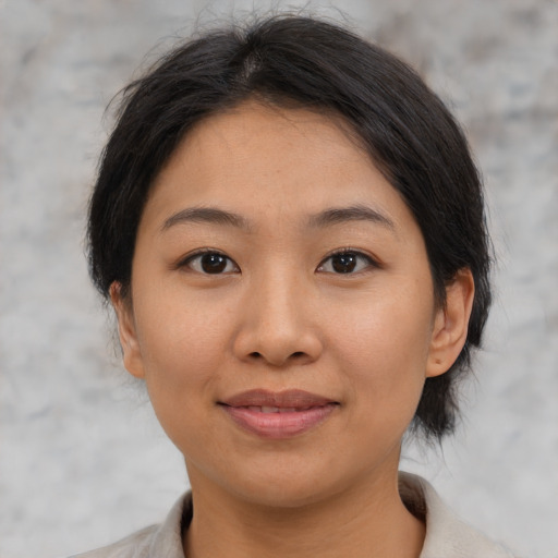 Joyful asian young-adult female with medium  brown hair and brown eyes
