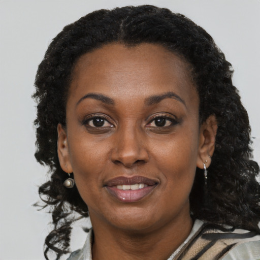 Joyful black adult female with short  black hair and brown eyes