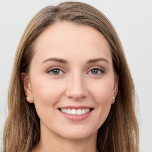 Joyful white young-adult female with long  brown hair and grey eyes