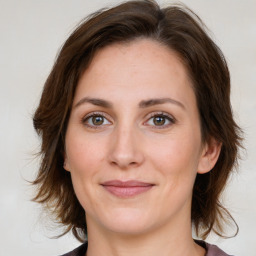 Joyful white young-adult female with medium  brown hair and green eyes