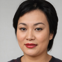 Joyful asian young-adult female with medium  black hair and brown eyes