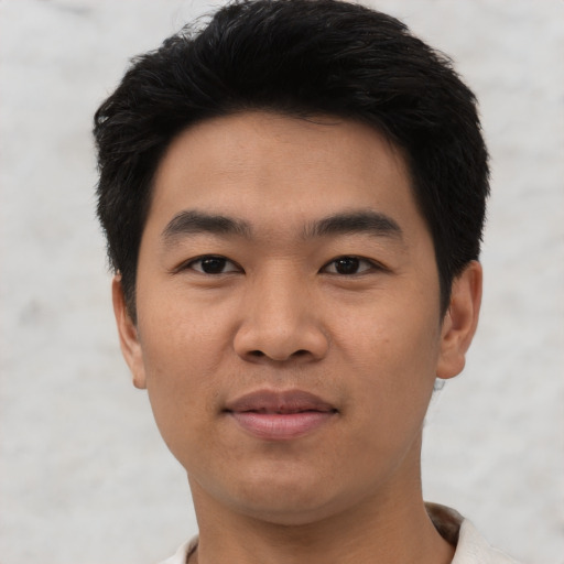 Joyful asian young-adult male with short  black hair and brown eyes