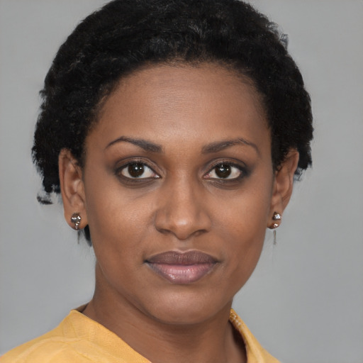 Joyful black young-adult female with short  brown hair and brown eyes