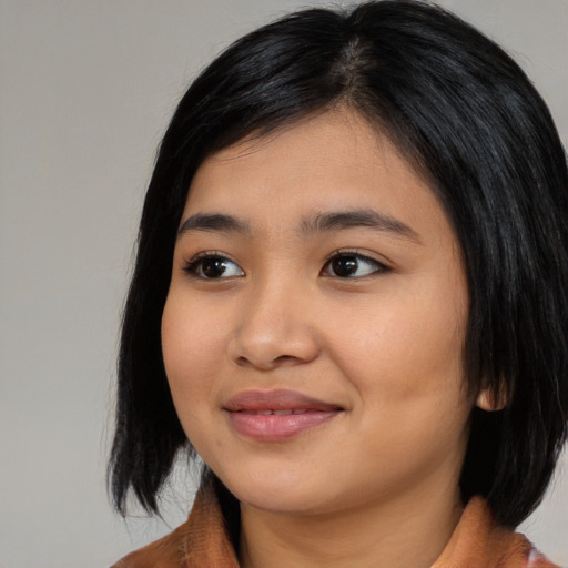 Joyful asian young-adult female with medium  black hair and brown eyes
