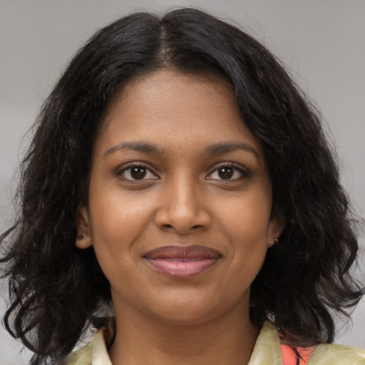 Joyful black young-adult female with medium  brown hair and brown eyes