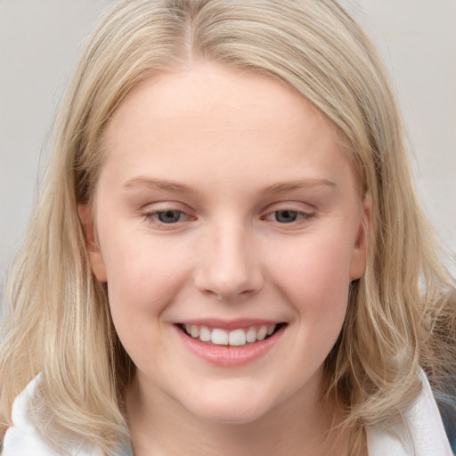 Joyful white young-adult female with long  brown hair and blue eyes