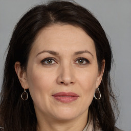 Joyful white adult female with long  brown hair and brown eyes