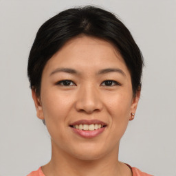 Joyful asian young-adult female with short  brown hair and brown eyes