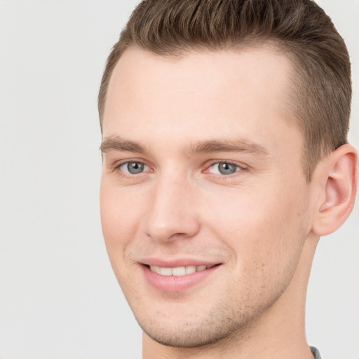 Joyful white young-adult male with short  brown hair and grey eyes