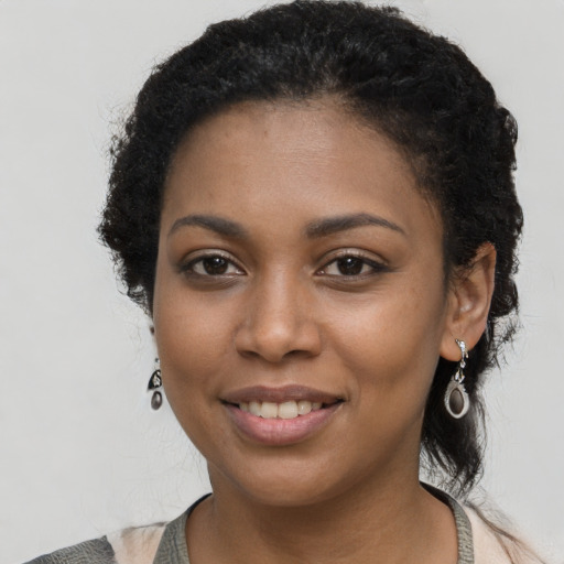 Joyful black young-adult female with long  black hair and brown eyes