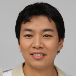 Joyful asian young-adult male with short  black hair and brown eyes