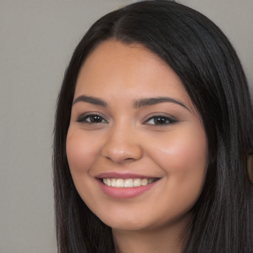 Joyful latino young-adult female with long  black hair and brown eyes