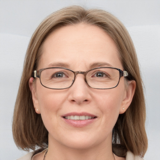 Joyful white adult female with medium  brown hair and blue eyes