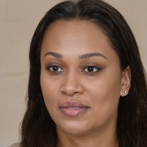 Joyful black young-adult female with long  brown hair and brown eyes