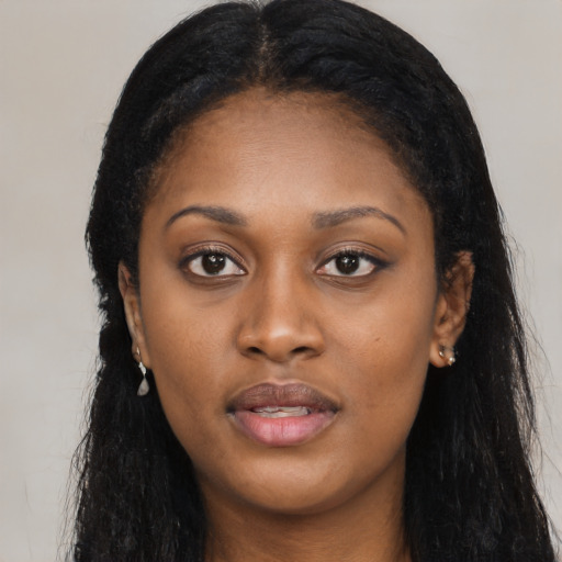 Joyful black young-adult female with long  black hair and brown eyes