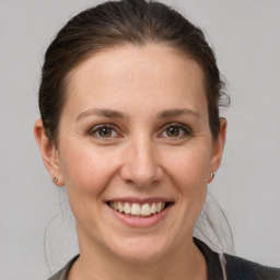 Joyful white young-adult female with medium  brown hair and grey eyes