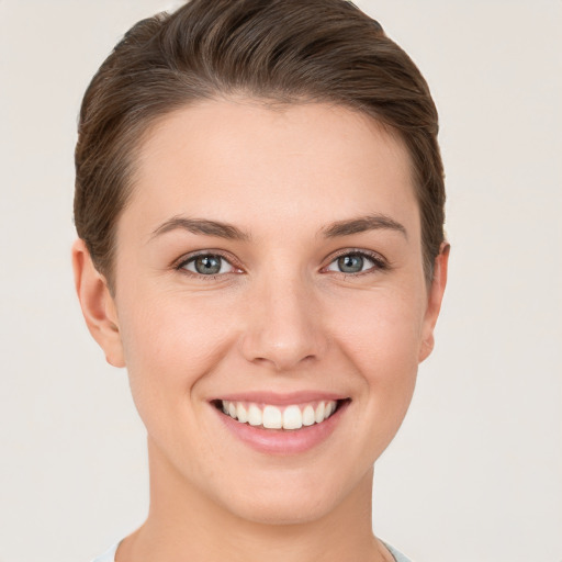 Joyful white young-adult female with short  brown hair and grey eyes