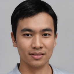 Joyful asian young-adult male with short  black hair and brown eyes