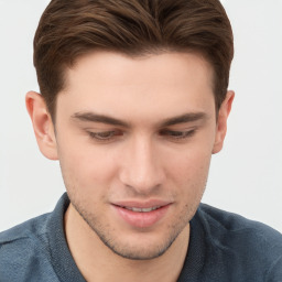 Joyful white young-adult male with short  brown hair and grey eyes