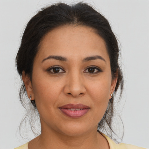 Joyful latino adult female with medium  brown hair and brown eyes