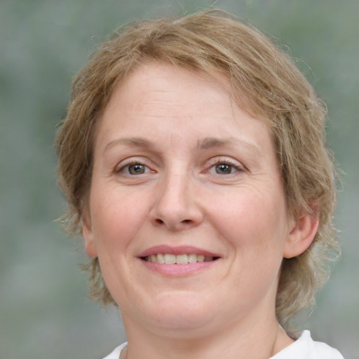 Joyful white adult female with medium  brown hair and green eyes