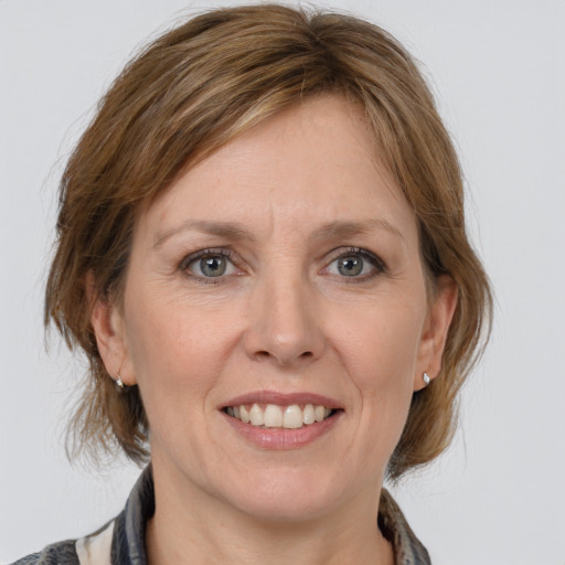 Joyful white adult female with medium  brown hair and grey eyes