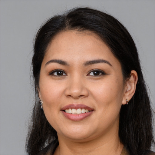 Joyful latino young-adult female with long  brown hair and brown eyes