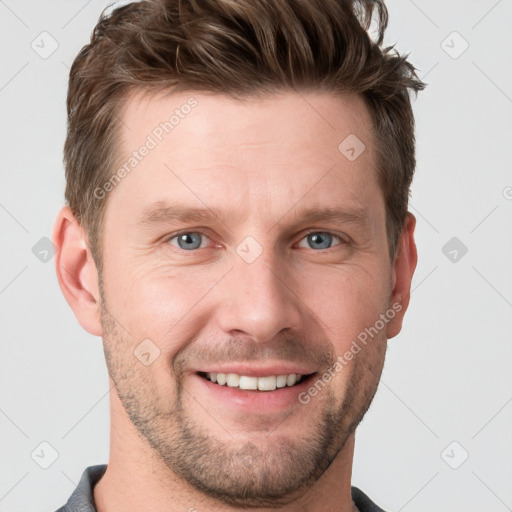 Joyful white young-adult male with short  brown hair and grey eyes