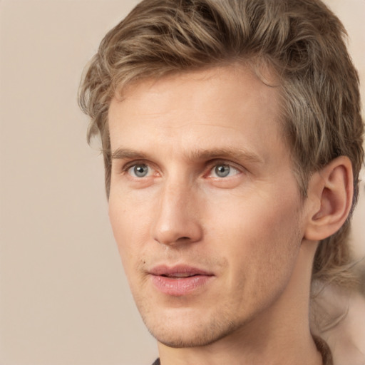 Joyful white young-adult male with short  brown hair and green eyes