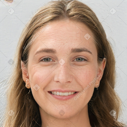 Joyful white adult female with long  brown hair and blue eyes