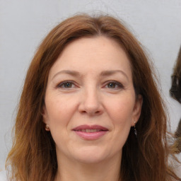 Joyful white adult female with long  brown hair and brown eyes