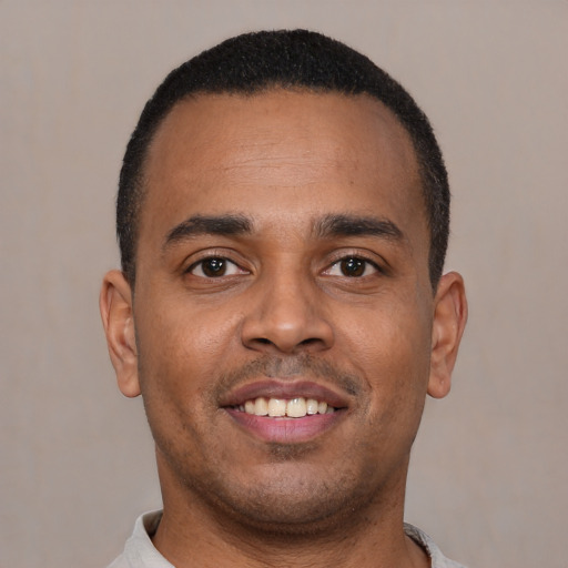 Joyful latino young-adult male with short  brown hair and brown eyes